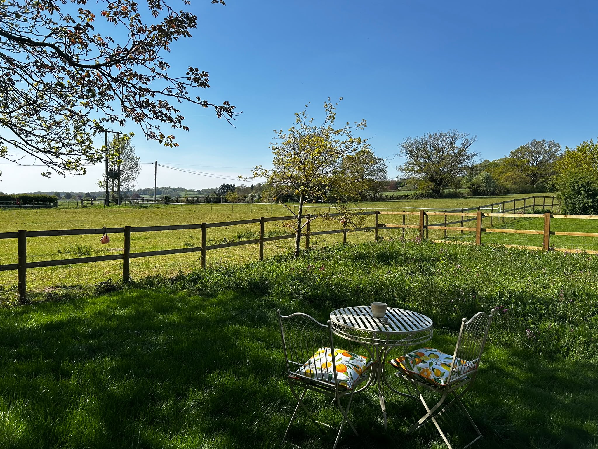 Bistro table and chairs in the garden looking over open fields