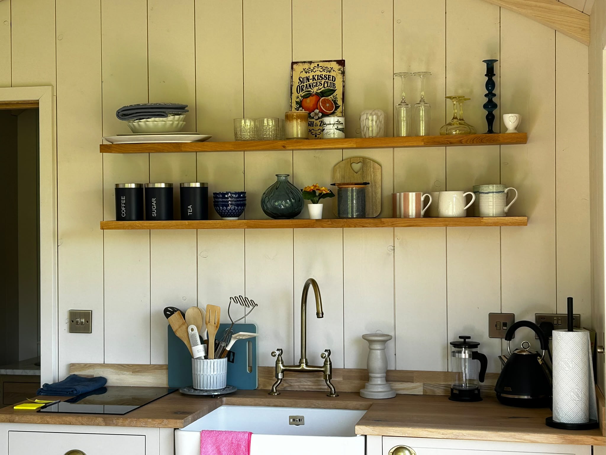 Open shelving above the kitchenette with crockery and glassware